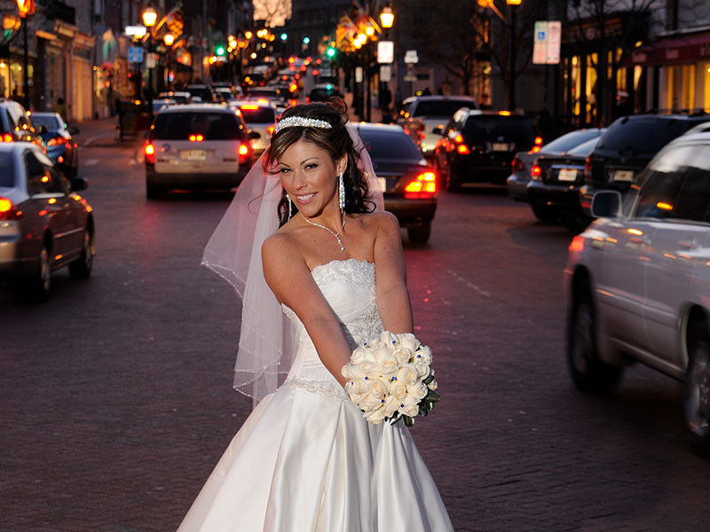 Beautiful, smiling, bride with bouquet in Annapolis, MD at the foot of main street